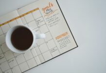 생산성 향상의 열쇠가 되는 직장 내 스트레스 관리 white ceramic mug with coffee on top of a planner