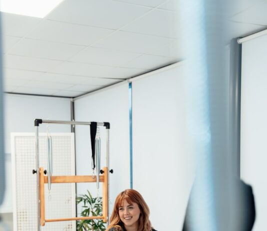 신체 정렬의 중요성, 필라테스로 몸의 균형 찾기 a woman is riding a stationary rowing machine