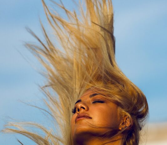 건강한 모발을 위한 생활습관, 매일 실천하는 헤어 케어 방법 woman wearing yellow halter top whipping hair