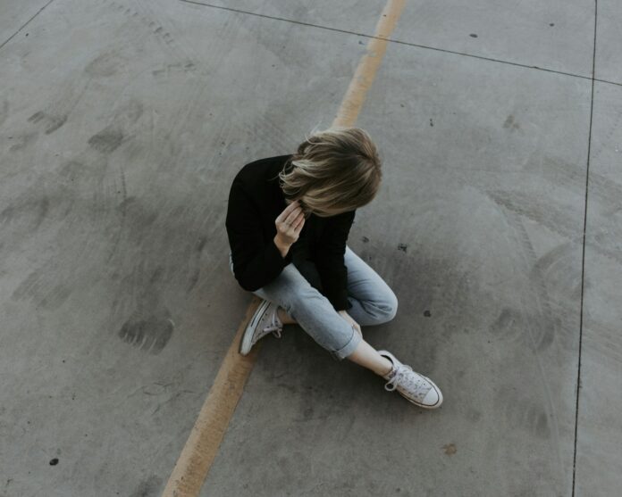 Photo by Austin Kehmeier woman sitting on pavement