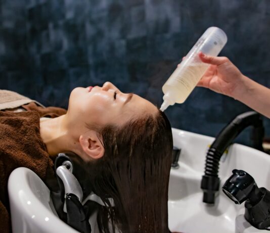 집에서도 똑똑하게! 건강한 헤어 케어 최신 트렌드와 실천 팁 a woman getting her hair washed with a hair dryer