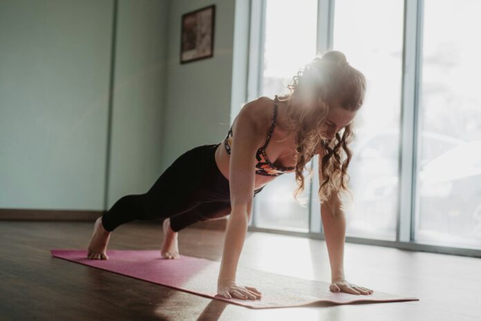 Photo by Olivia Bauso woman in black tank top and black leggings doing yoga
