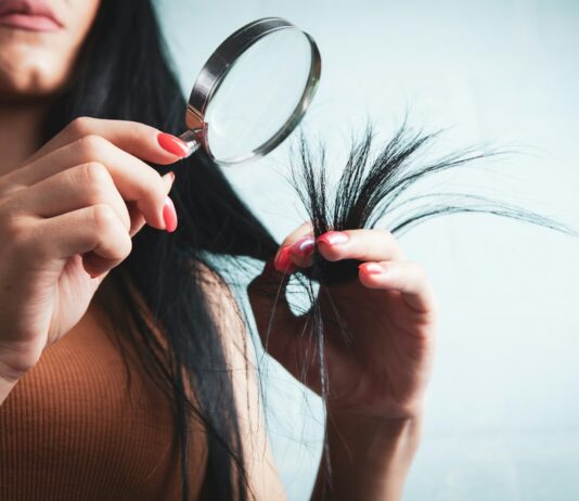 건강한 헤어 트렌드, 일상 습관이 좌우한다 Woman examining split ends of hair with magnifying glass