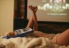 ‘저녁 8시 이후 금식’… 최근 떠오르는 ‘마지막 식사 시간 지키기’ 건강습관 인기 a person laying on a bed with a bag of popcorn