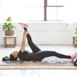 바쁜 일상 속 ‘웰니스 회복’, 나만의 작은 휴식이 건강을 지킨다 woman in black tank top and black leggings lying on black and white floral area rug
