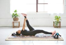 바쁜 일상 속 ‘웰니스 회복’, 나만의 작은 휴식이 건강을 지킨다 woman in black tank top and black leggings lying on black and white floral area rug